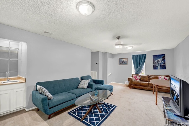 living area with light carpet, a textured ceiling, and visible vents