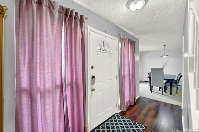 entrance foyer featuring baseboards, a textured ceiling, and dark wood finished floors