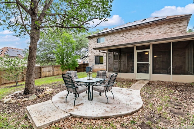 view of patio / terrace featuring a fenced backyard, outdoor dining space, and a sunroom