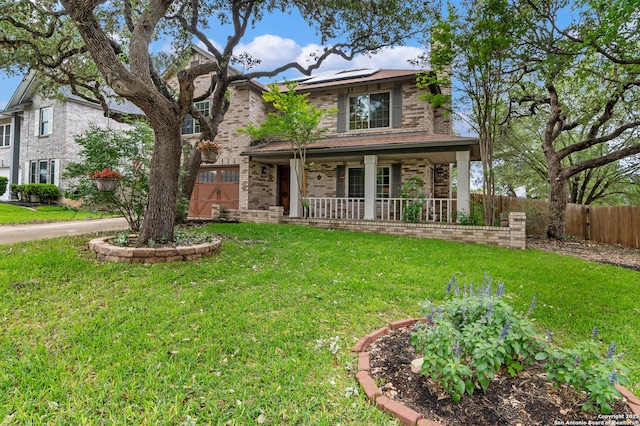 traditional-style house featuring a front lawn, roof mounted solar panels, fence, and covered porch