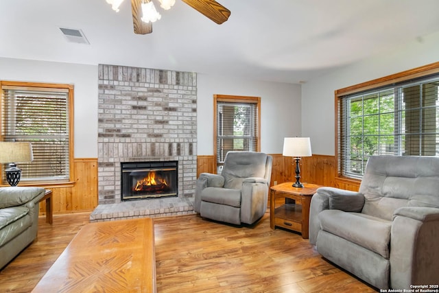 living room with visible vents, wainscoting, plenty of natural light, and wood finished floors