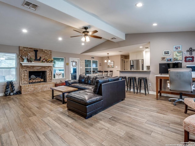 living room with baseboards, lofted ceiling with beams, light wood-type flooring, and visible vents