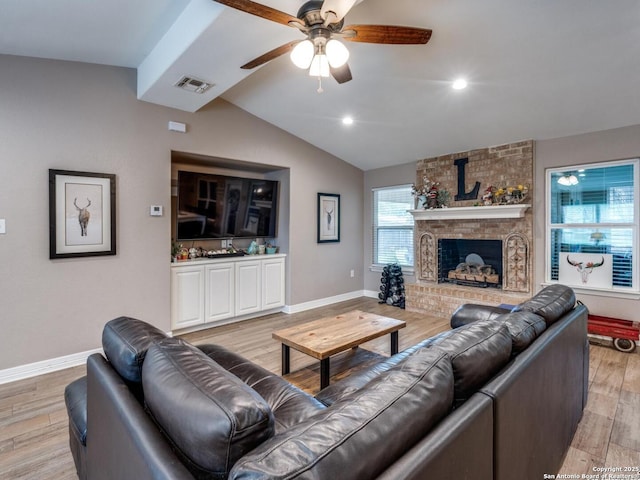 living area featuring visible vents, lofted ceiling, baseboards, ceiling fan, and light wood-style flooring