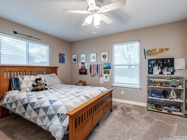 bedroom featuring a ceiling fan, baseboards, multiple windows, and carpet