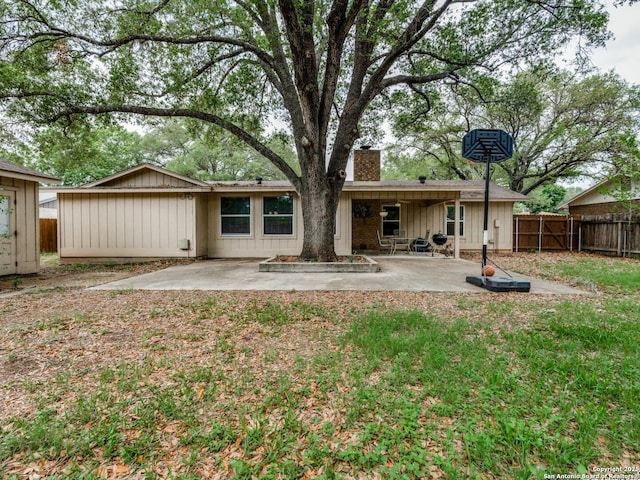 back of house featuring a fenced backyard, a patio area, and a chimney