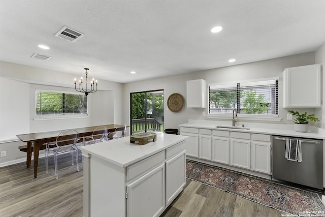 kitchen with a sink, light wood-style floors, light countertops, dishwasher, and white cabinetry
