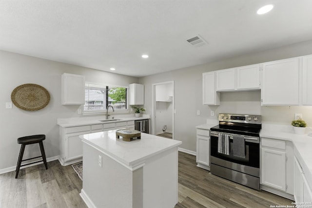 kitchen with white cabinets, a sink, light countertops, a center island, and stainless steel electric stove