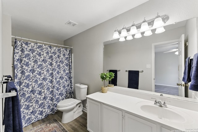 bathroom with vanity, toilet, a shower with shower curtain, wood finished floors, and visible vents