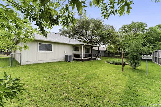 back of property with a lawn, a deck, central AC unit, and a fenced backyard
