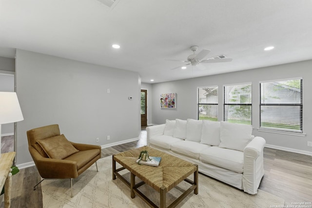 living room with baseboards, visible vents, a healthy amount of sunlight, and light wood-type flooring