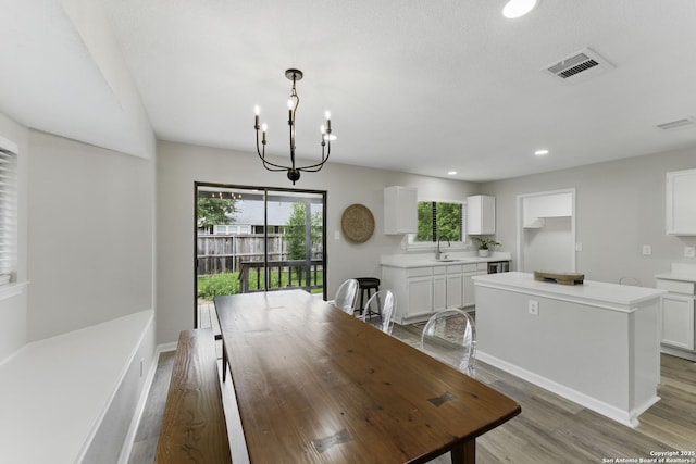 dining area featuring an inviting chandelier, a wealth of natural light, and visible vents