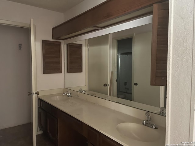 bathroom featuring a sink, a shower with shower door, and double vanity