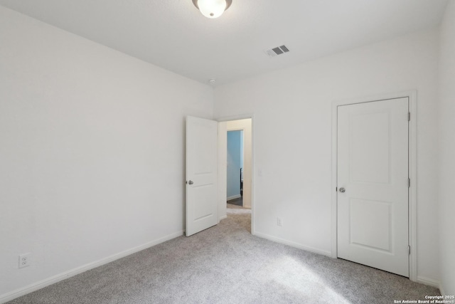 unfurnished bedroom with baseboards, visible vents, and carpet