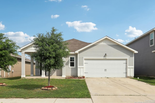 ranch-style house featuring a garage, roof with shingles, driveway, and a front lawn
