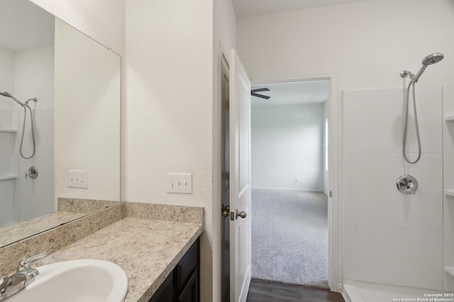 full bath featuring vanity, a shower, and wood finished floors