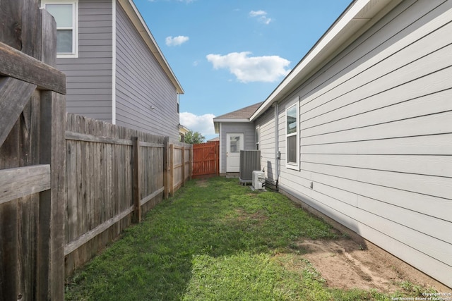 view of yard featuring central air condition unit and fence