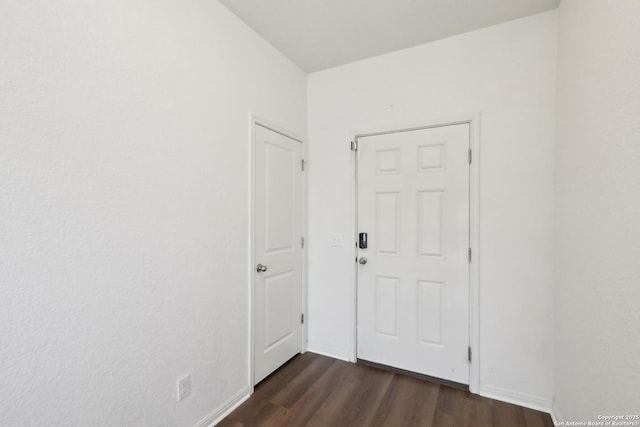 interior space featuring dark wood-type flooring and baseboards