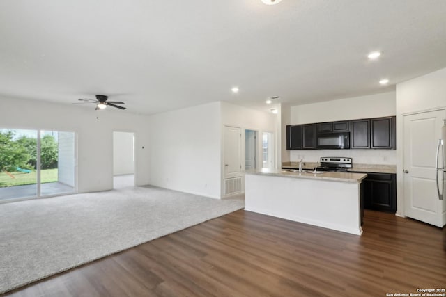 kitchen featuring stainless steel electric range oven, black microwave, recessed lighting, open floor plan, and dark wood-type flooring