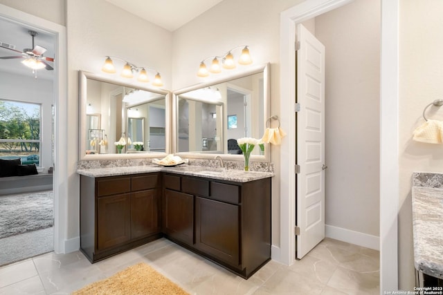 ensuite bathroom with vanity, baseboards, ceiling fan, and ensuite bathroom