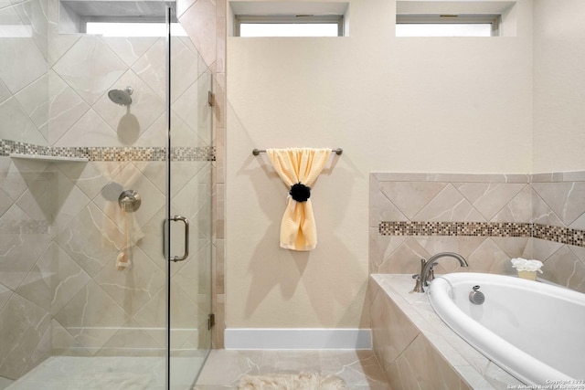 full bathroom with baseboards, a shower stall, and a garden tub