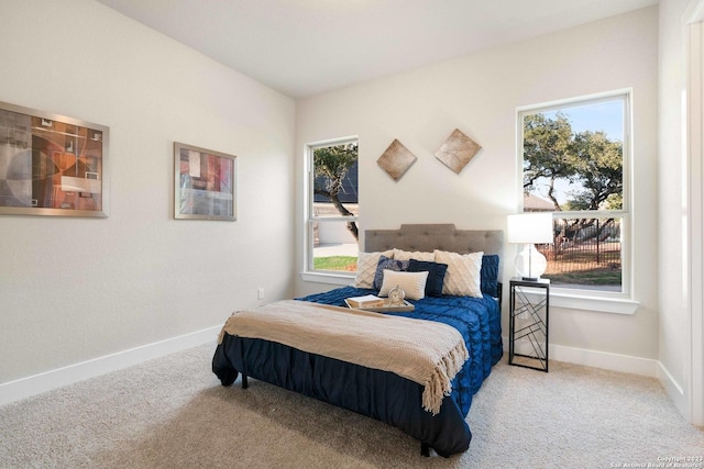 bedroom featuring baseboards, multiple windows, and carpet