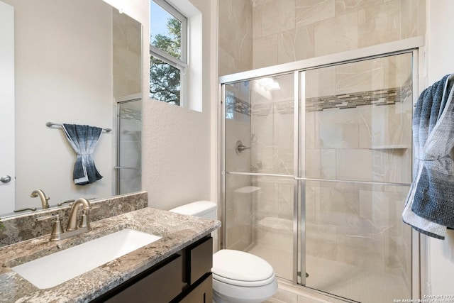 bathroom with vanity, toilet, and a stall shower