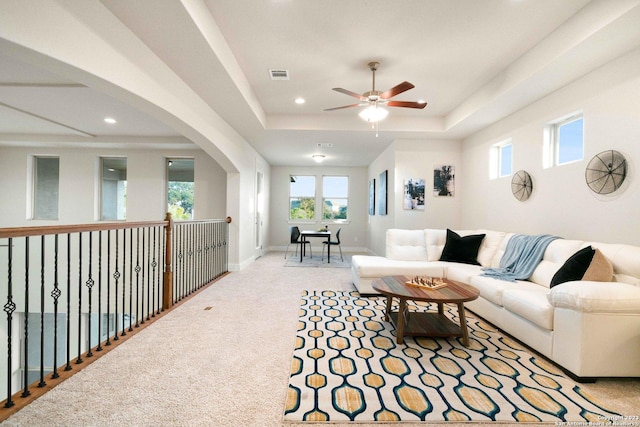 carpeted living area with a ceiling fan, a tray ceiling, recessed lighting, and visible vents