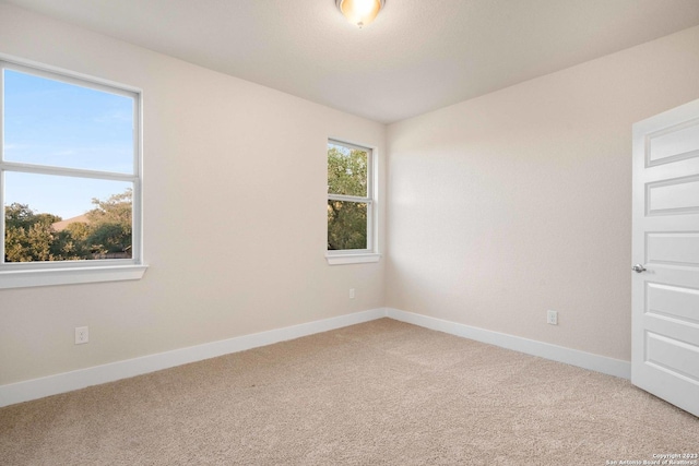 carpeted empty room with baseboards