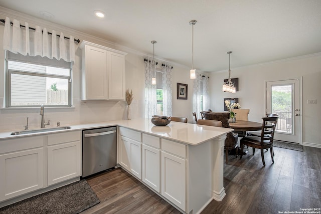kitchen featuring white cabinets, a sink, a peninsula, dark wood-type flooring, and stainless steel dishwasher