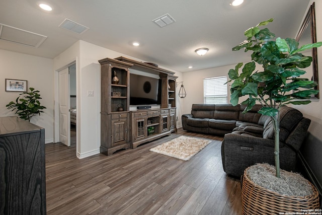 living room with visible vents, attic access, baseboards, and dark wood-style floors