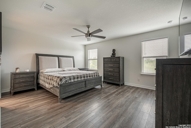 bedroom with baseboards, ceiling fan, dark wood-style flooring, and visible vents