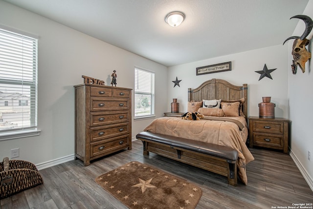 bedroom with dark wood-type flooring and baseboards