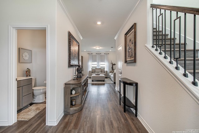 hallway with crown molding, baseboards, dark wood-style floors, and stairway