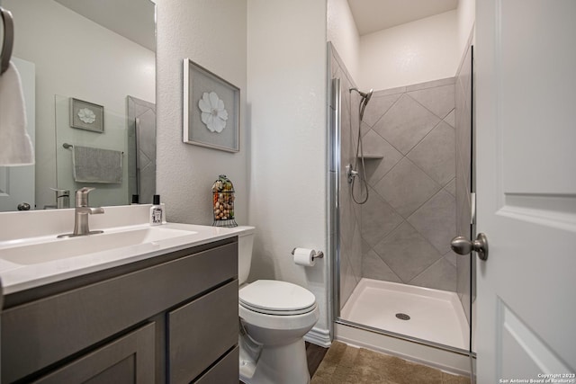 bathroom with vanity, toilet, and tiled shower