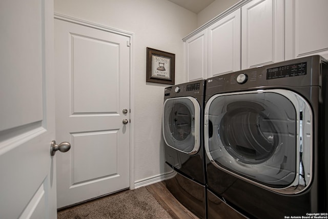 laundry area with baseboards, cabinet space, washing machine and dryer, and dark wood finished floors