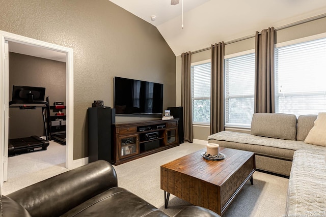 carpeted living room with baseboards, a ceiling fan, a textured wall, and vaulted ceiling