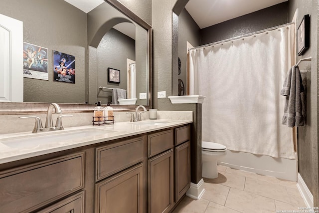 full bath with a sink, a textured wall, tile patterned floors, and toilet