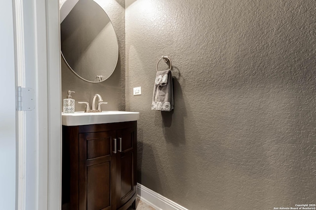 bathroom featuring vanity and a textured wall