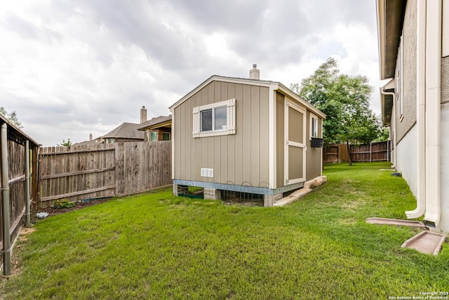 view of outdoor structure featuring a fenced backyard and an outbuilding