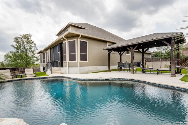 view of swimming pool with a gazebo, fence, a patio area, and a sunroom