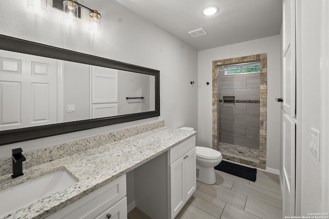 bathroom featuring vanity, a stall shower, visible vents, and toilet