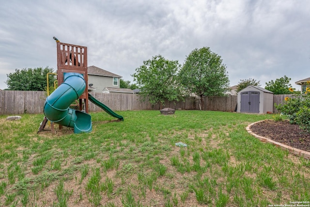 view of yard with a storage unit, a fenced backyard, a playground, and an outdoor structure