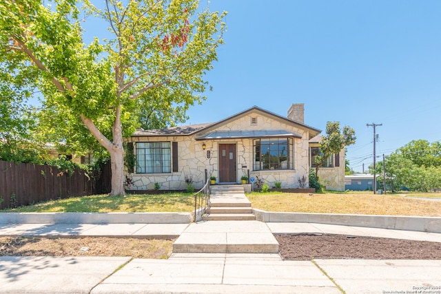 700 Dawson, San Antonio, TX 78202 - bungalow-style house featuring fence, a chimney, a front yard, and stone siding