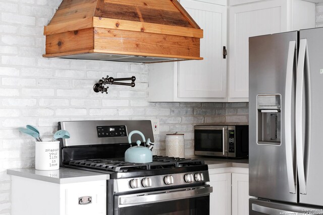 700 Dawson, San Antonio, TX 78202 - kitchen featuring custom range hood, white cabinetry, appliances with stainless steel finishes, and tasteful backsplash