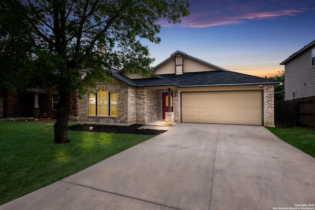 ranch-style home featuring fence, a front lawn, brick siding, a garage, and driveway