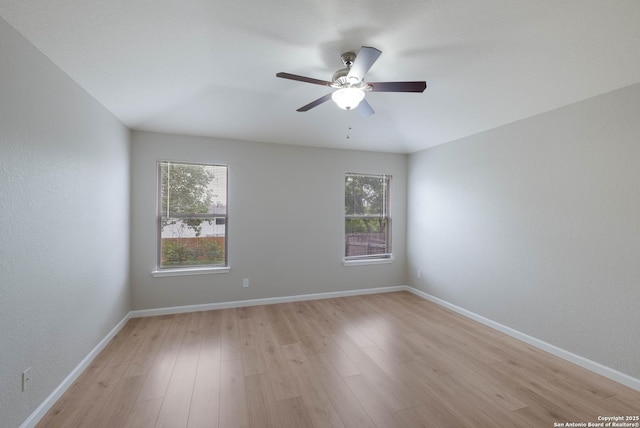 empty room featuring baseboards, light wood finished floors, and ceiling fan