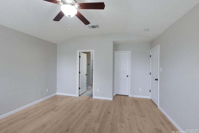 unfurnished bedroom with baseboards, visible vents, light wood finished floors, and vaulted ceiling