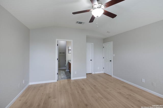 unfurnished bedroom with connected bathroom, light wood-style flooring, baseboards, lofted ceiling, and visible vents