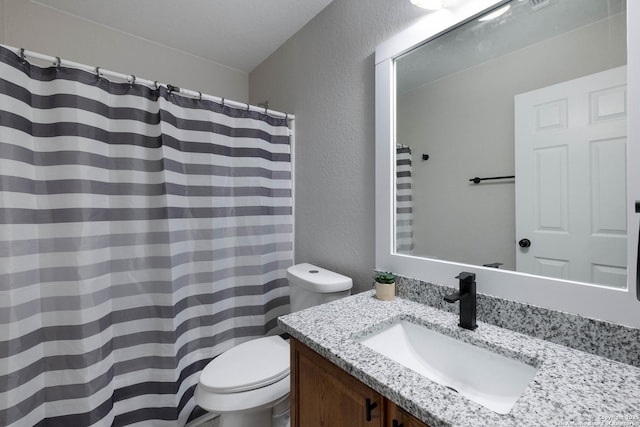 full bath with vanity, a textured wall, toilet, and a shower with curtain