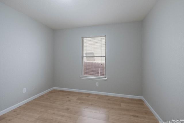 empty room with baseboards and light wood-style flooring